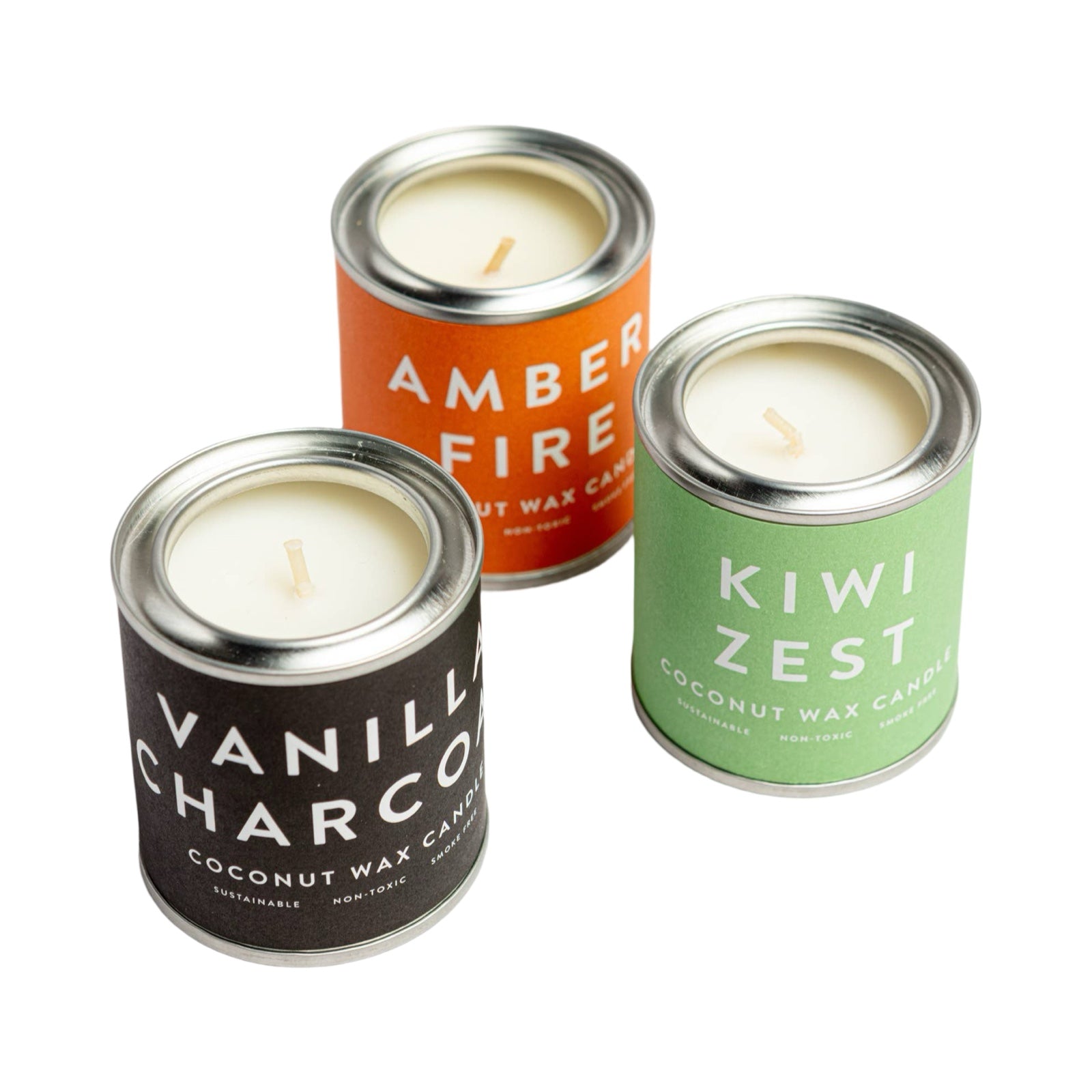 3 coconut wax candles in small paint tins, 1 vanilla charcoal, 1 amber fire and 1 kiwi zest.