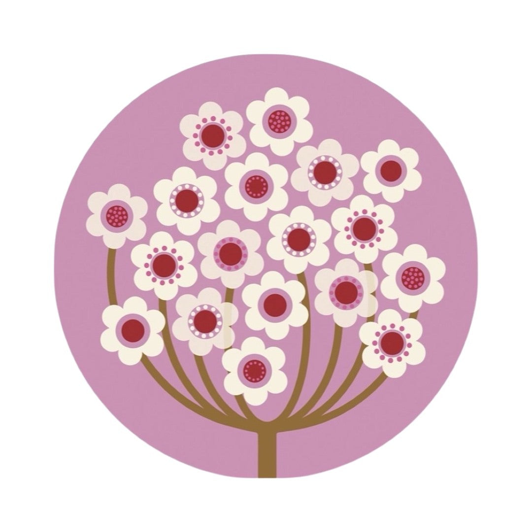A round placemat featuring an abstract verbena flower design in lilac, red and white.