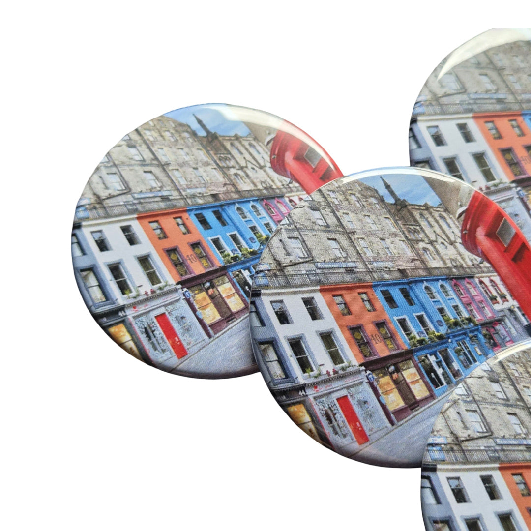 Set of three circular magnets with colorful building design on a white background