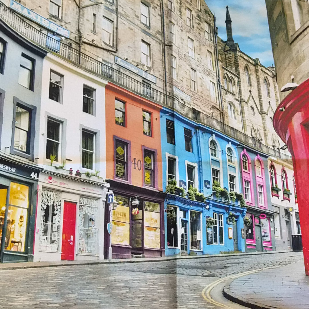 Colorful row of shops on a street with a historic building in the background