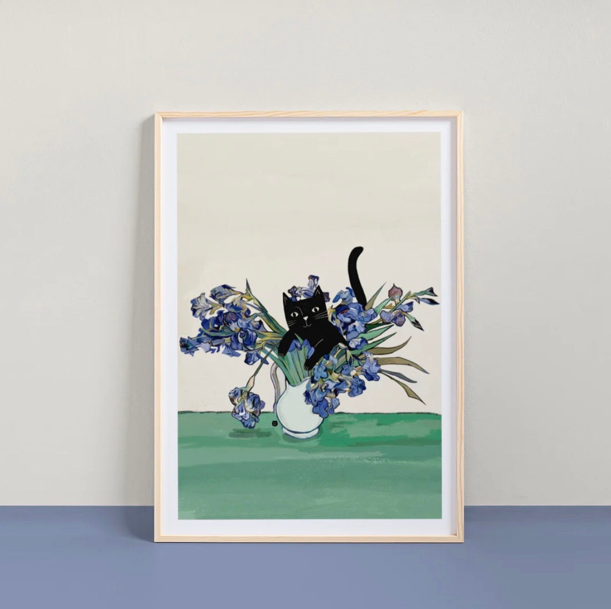 Framed artwork of a black cat sitting in a vase of flowers on a plain background.