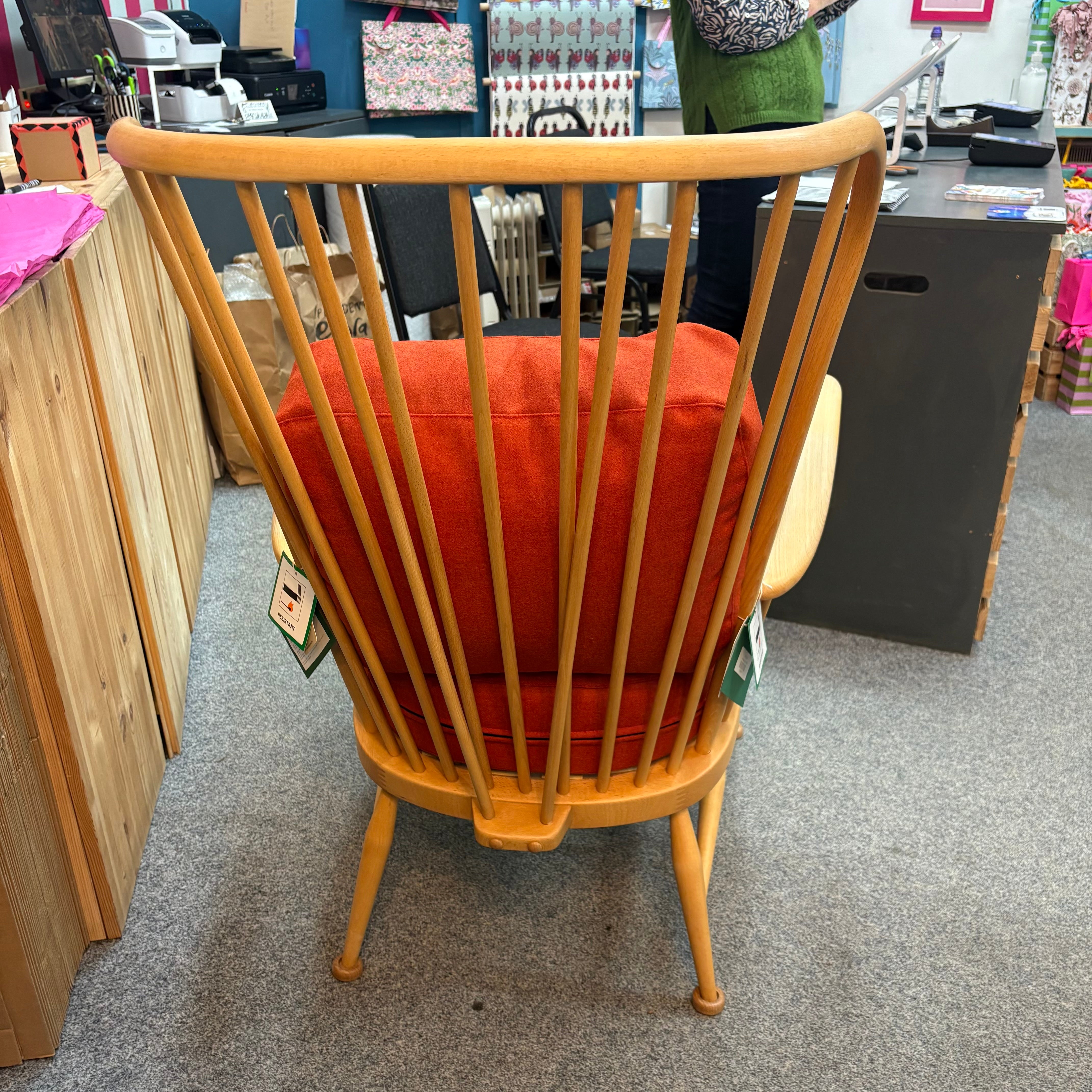 Wooden chair with red cushion in a shop.