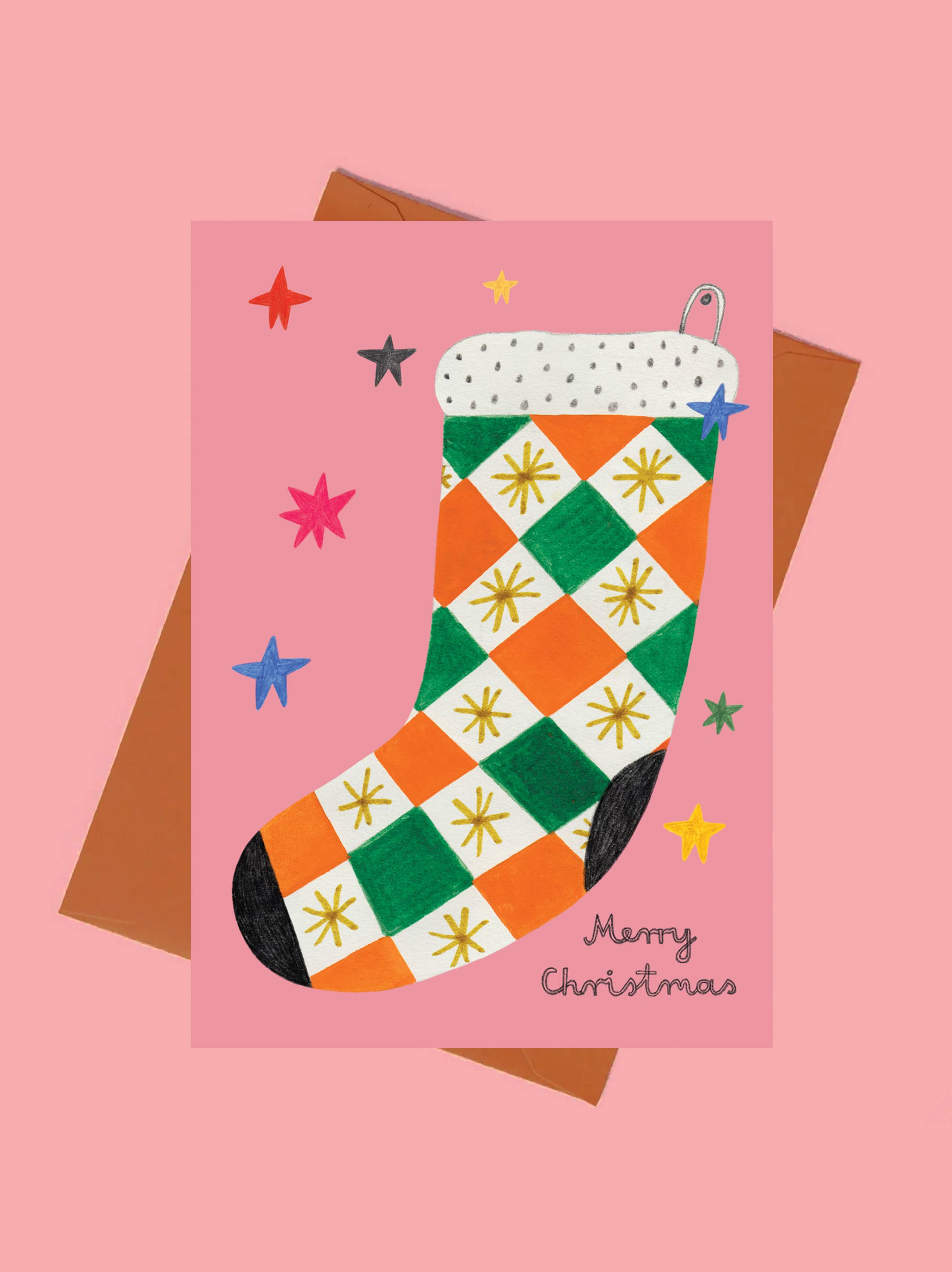 Christmas card with a colorful checkered stocking on a pink background.