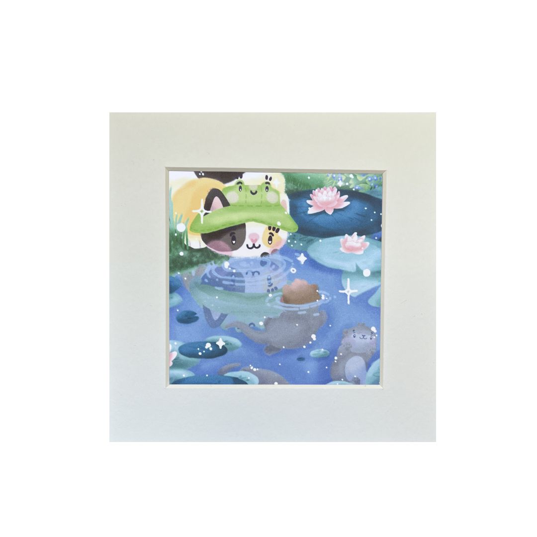 Illustrated print of a calico cat wearing a frog bucket hat, at a waterlily pond with some baby otters. Includes white sparkle-shaped details. 