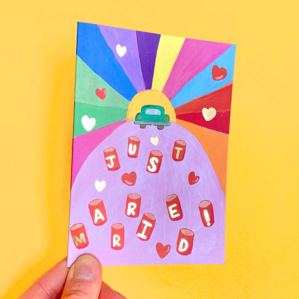 Colourful card with a card and 'Just Married' text with heart shapes on a yellow background.