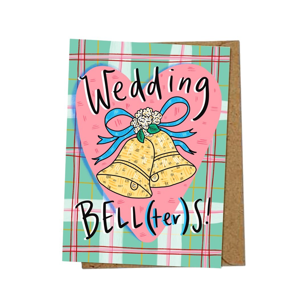 Wedding day card featuring 2 big gold bells tied with blue ribbon inside a pink love heart on a pink and green checked background and the text 'Wedding BELL(ter)'S'.