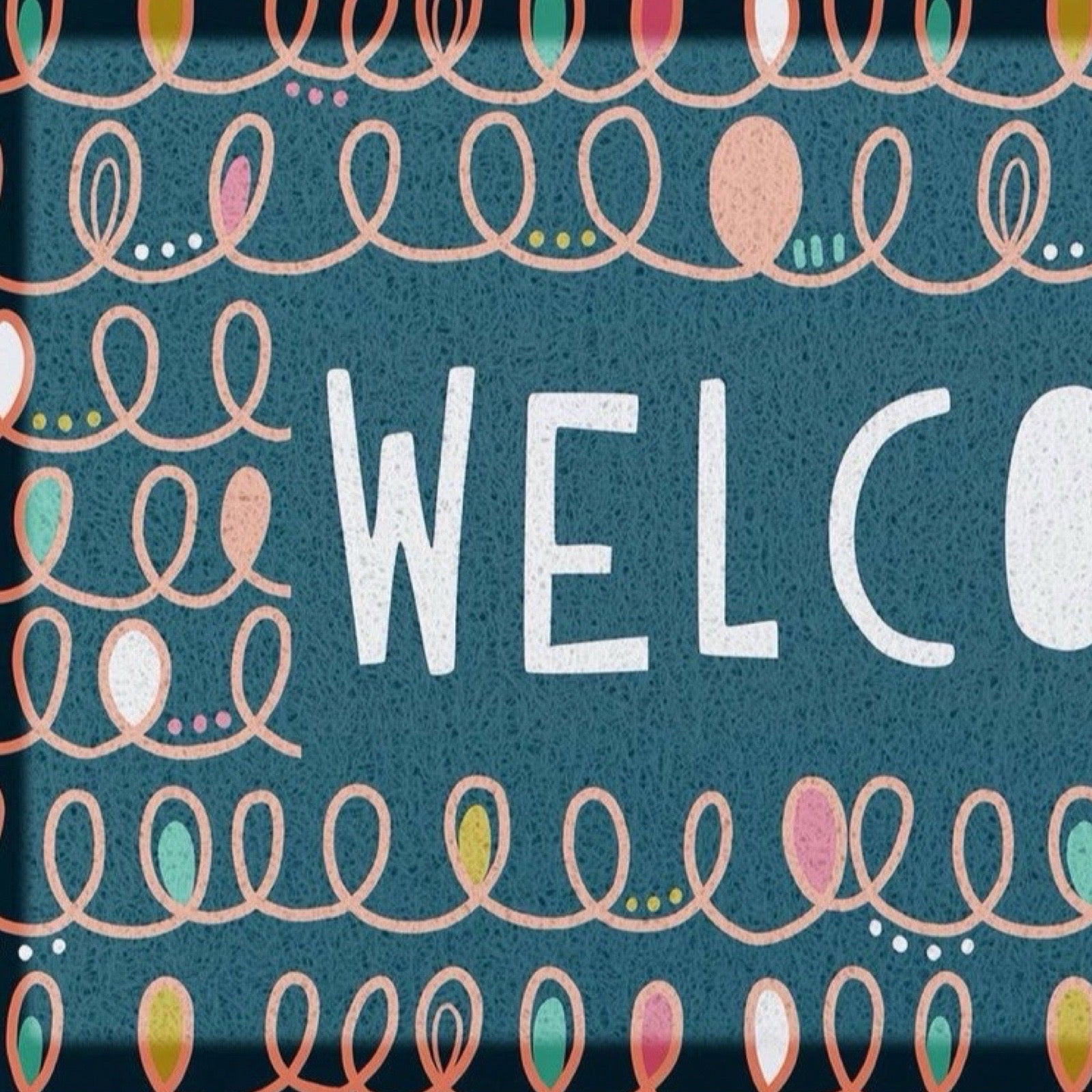 A square decorative doormat word "WELCO" in large white letters on a textured dark teal background, surrounded by repeating peach abstract loop patterns and small multicoloured dots.