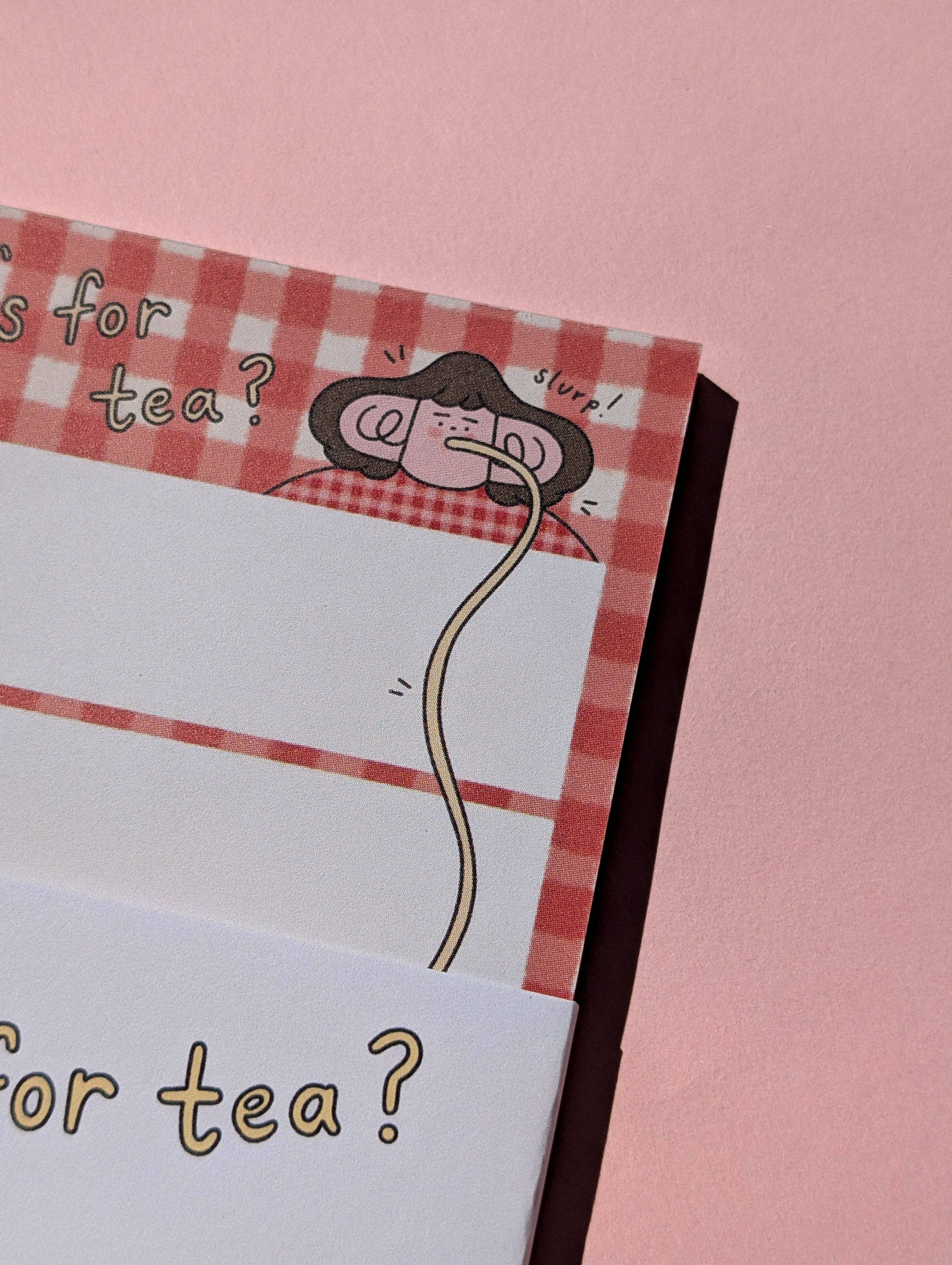 Notebook with a red checkered cover and cartoon character eating pasta on a pink background.