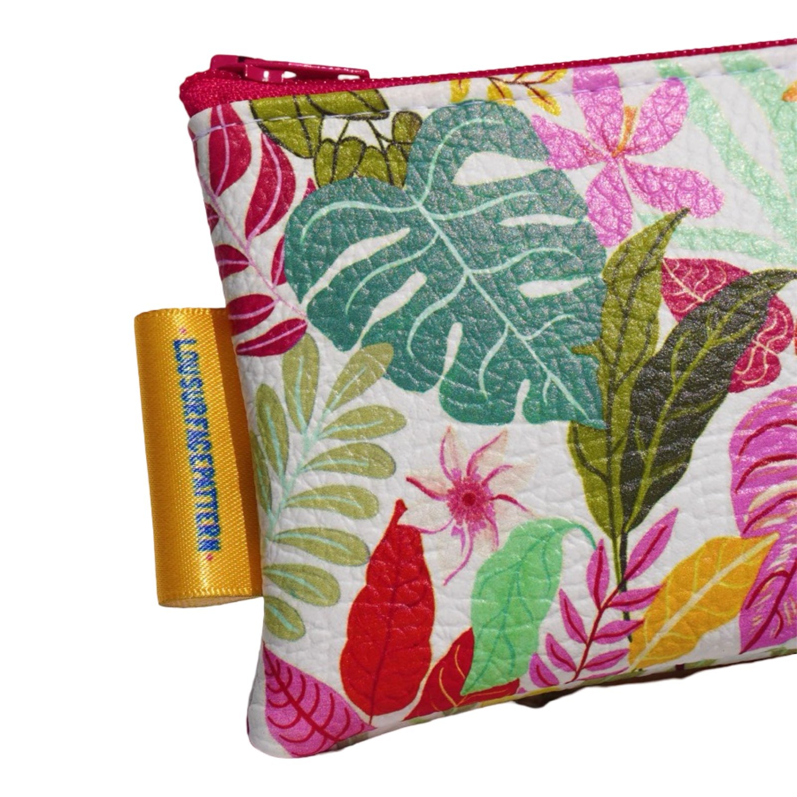 Vegan leather purse with colourful tropical leaves against a white background. 
