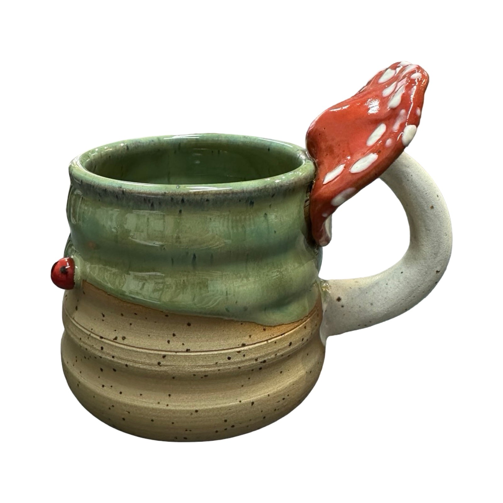 Ceramic mug with a handle shaped like a piece of mushroom on a white background.