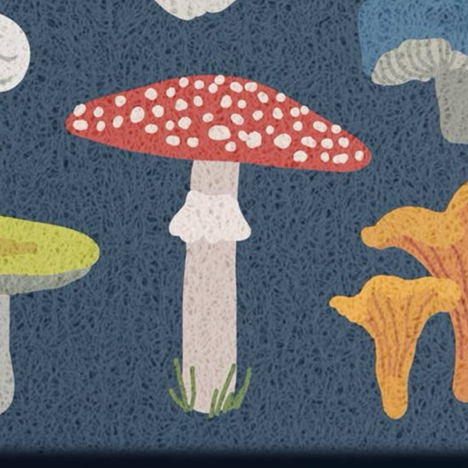 A close-up of doormat featuring whimsical illustrated mushrooms on a dark blue background, including a red-and-white spotted mushroom, a yellow-orange chanterelle, and partial green and white mushrooms.