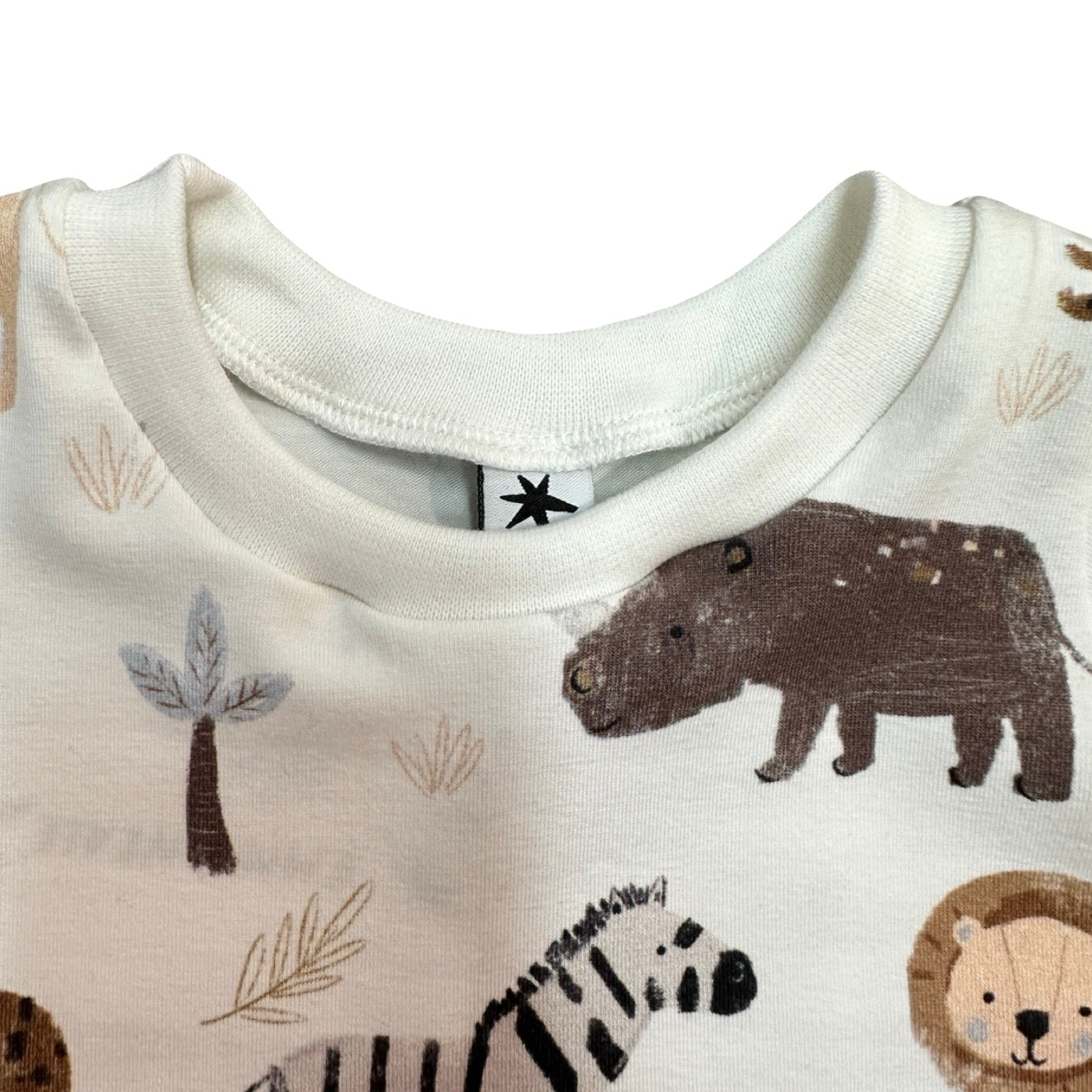 Close-up of a baby top with animal prints on a white background.
