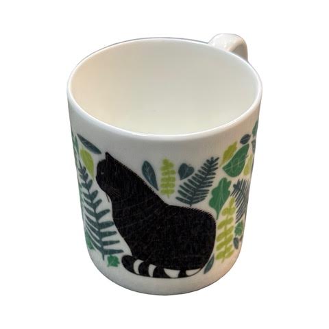 A white fine-bone china mug featuring an illustration of a black and white wildcat surrounded by green leaves.