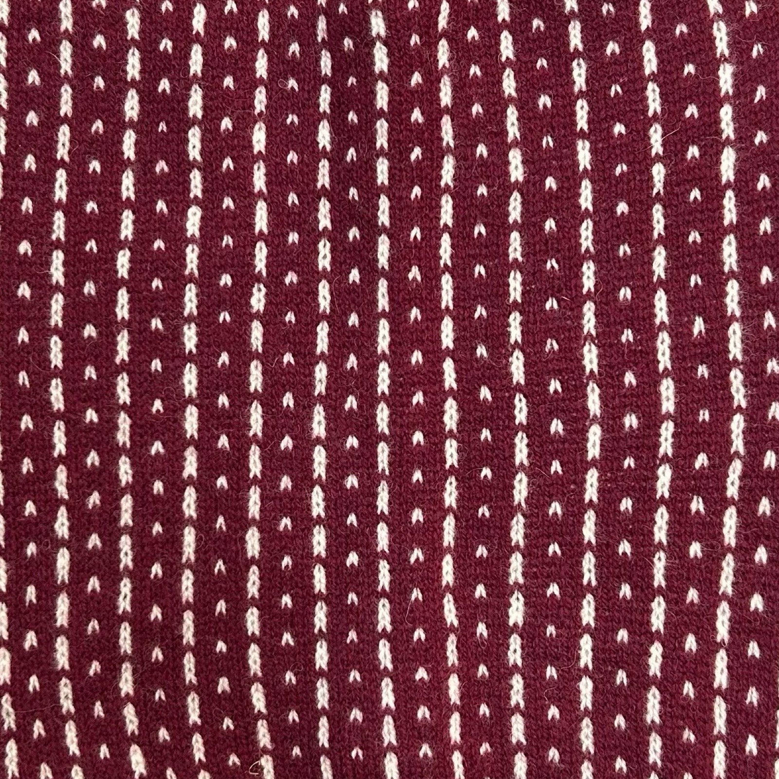 A cosy 100% lambswool knitted snood in wine with light grey dashes.