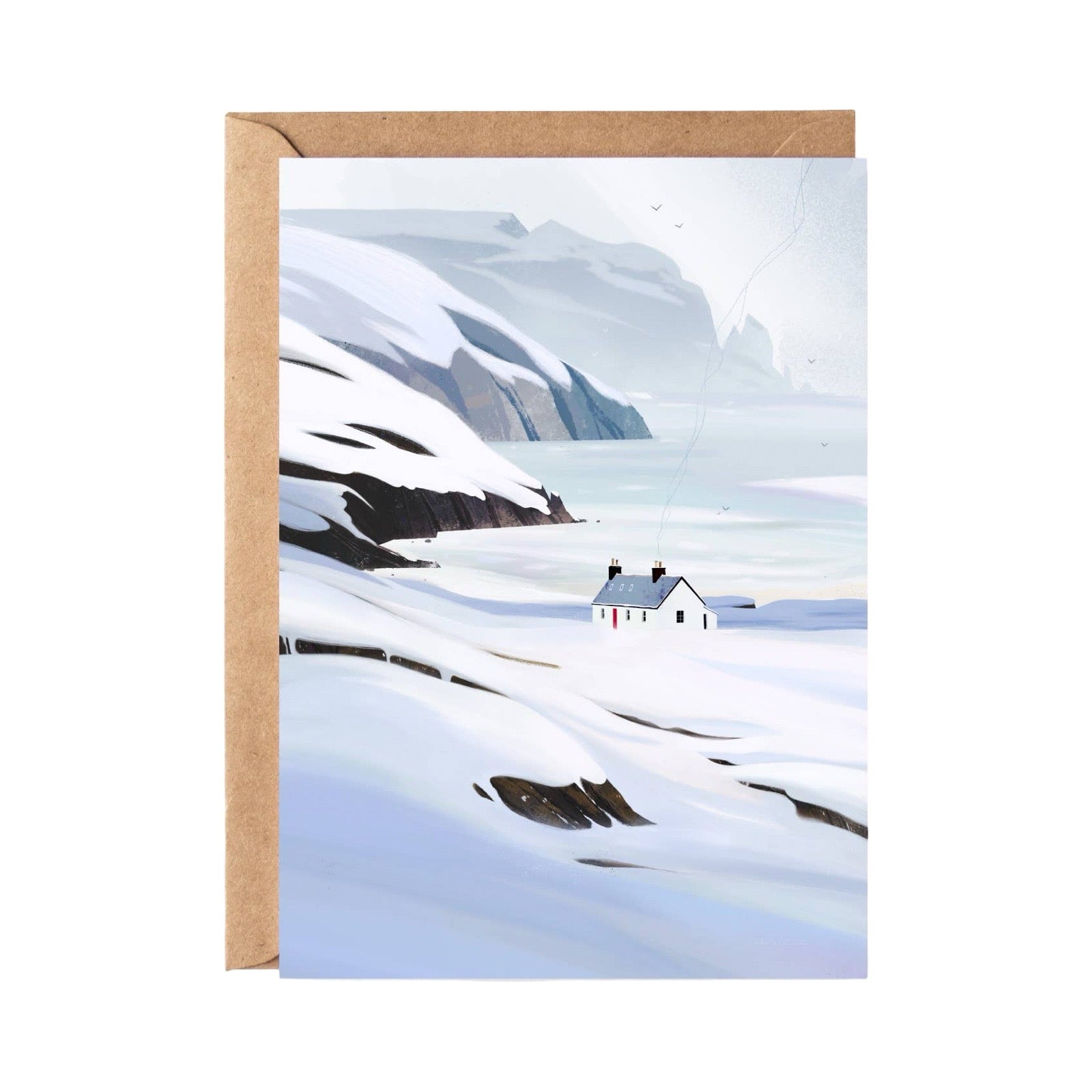 A greeting card featuring a minimalist winter landscape illustration with snow-covered mountains, a small white house, and a pale blue sky, shown with a brown kraft envelope behind it on a white background.