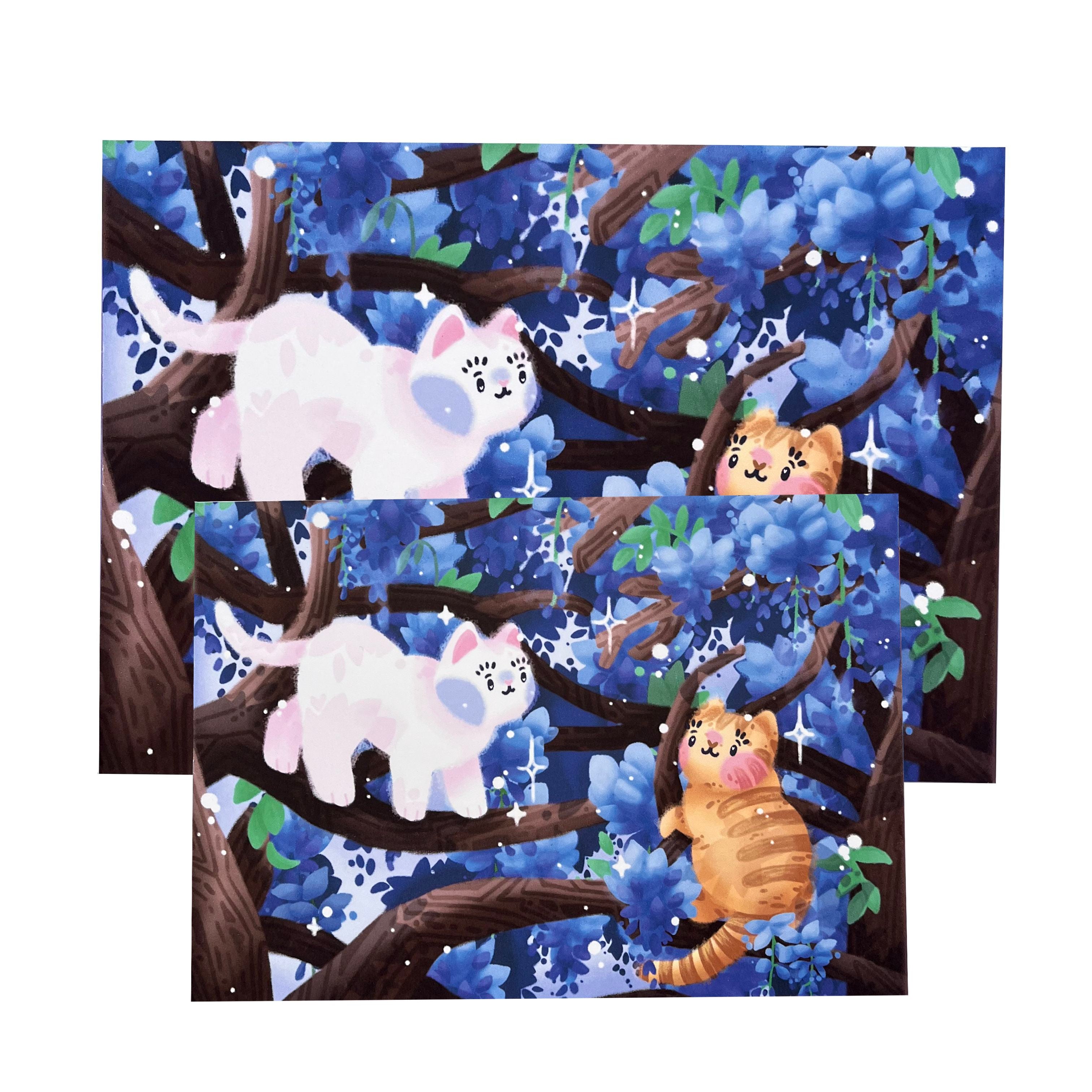 Photo of two art prints atop each other, of an illustration of two cats (white, left, and ginger, right) in wisteria trees, in A4 and A5 size
