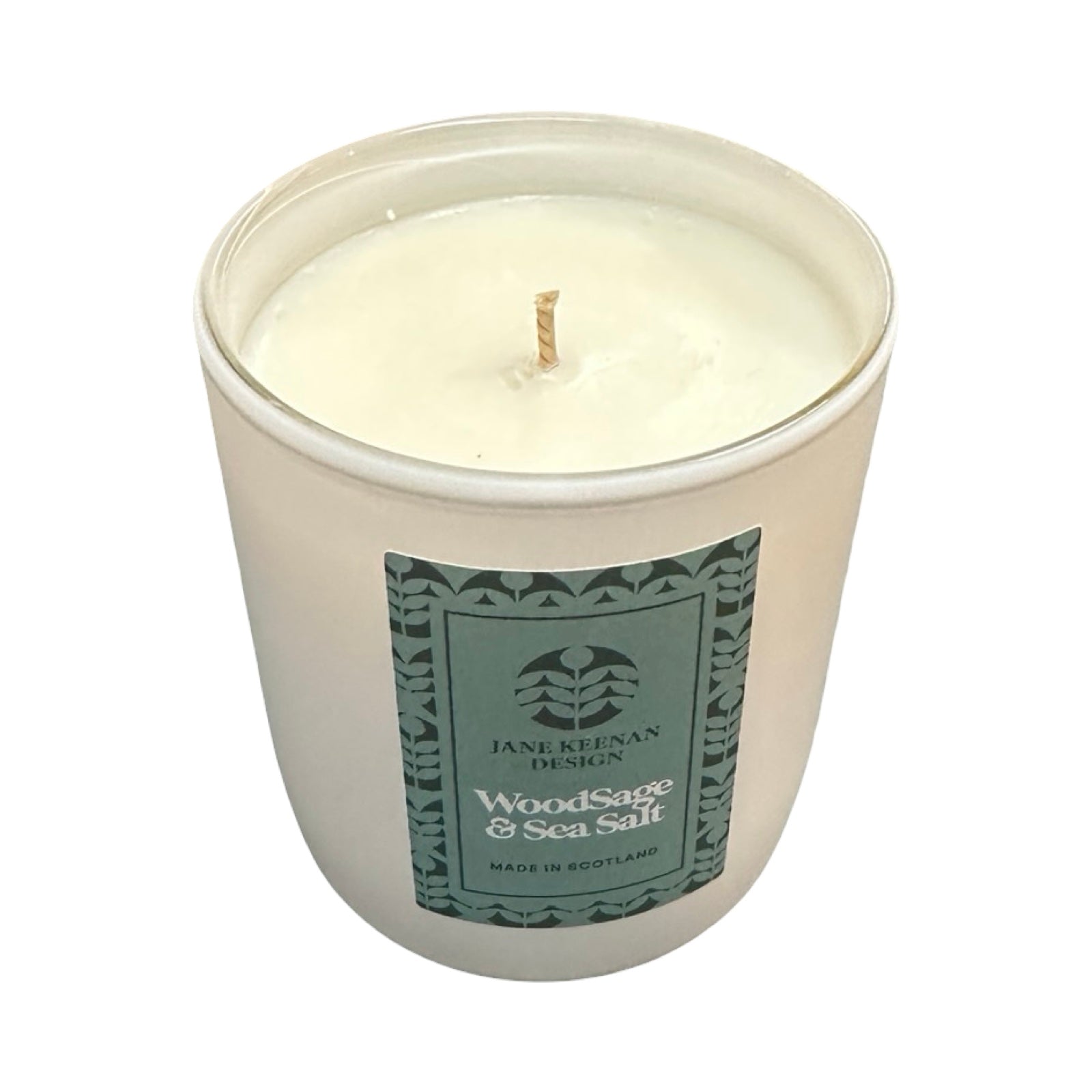 Candle in a white container with a green label on a white background.