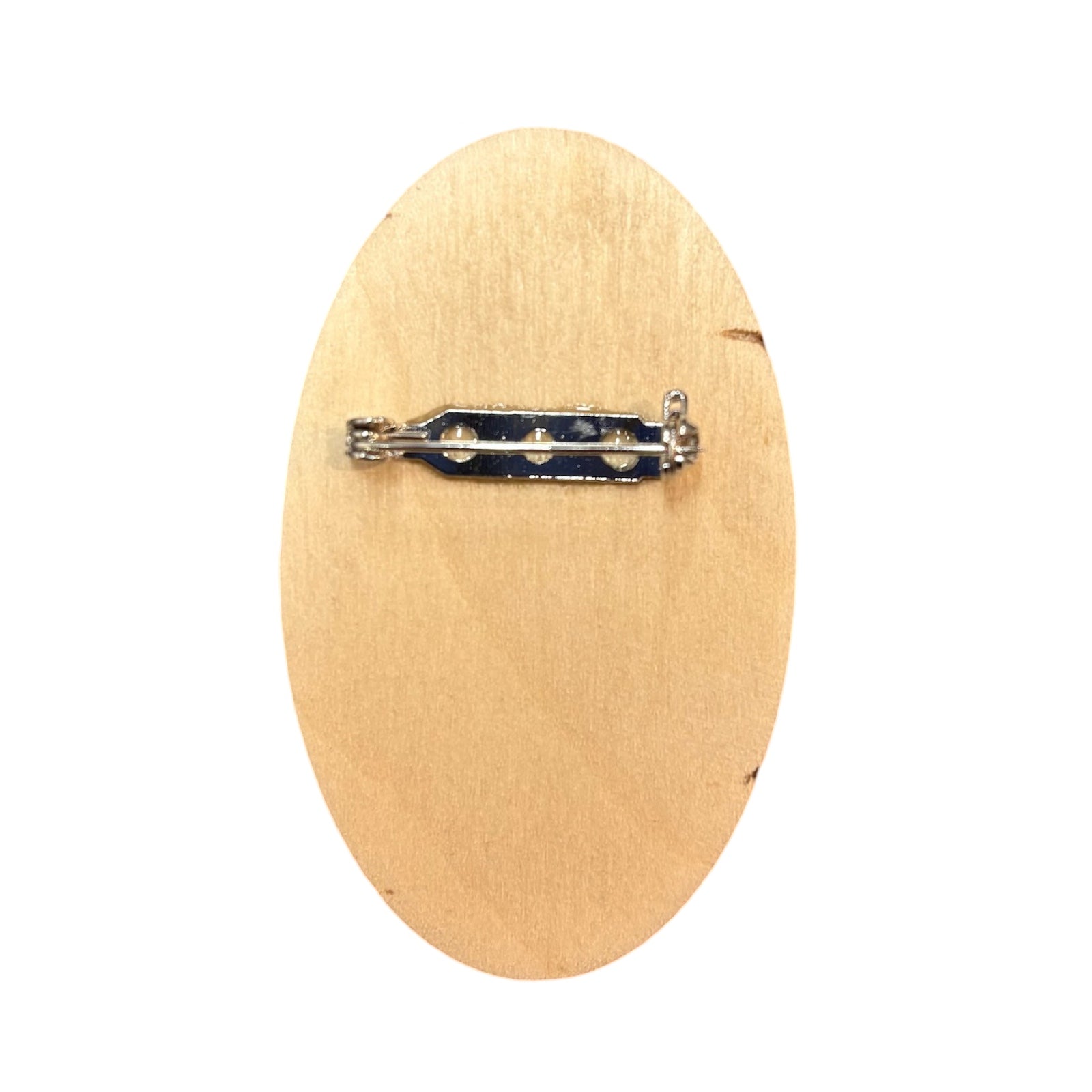 The back of a oval-shaped wooden brooch with a silver clasp.