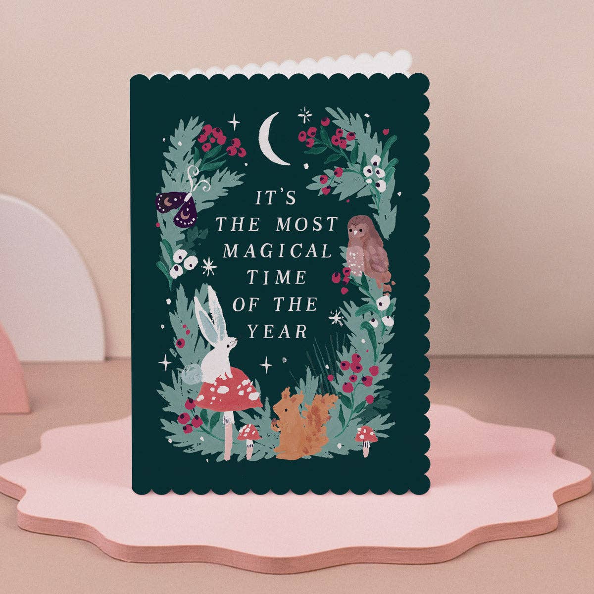 Decorative card with forest-themed illustrations and text on a pink stand.