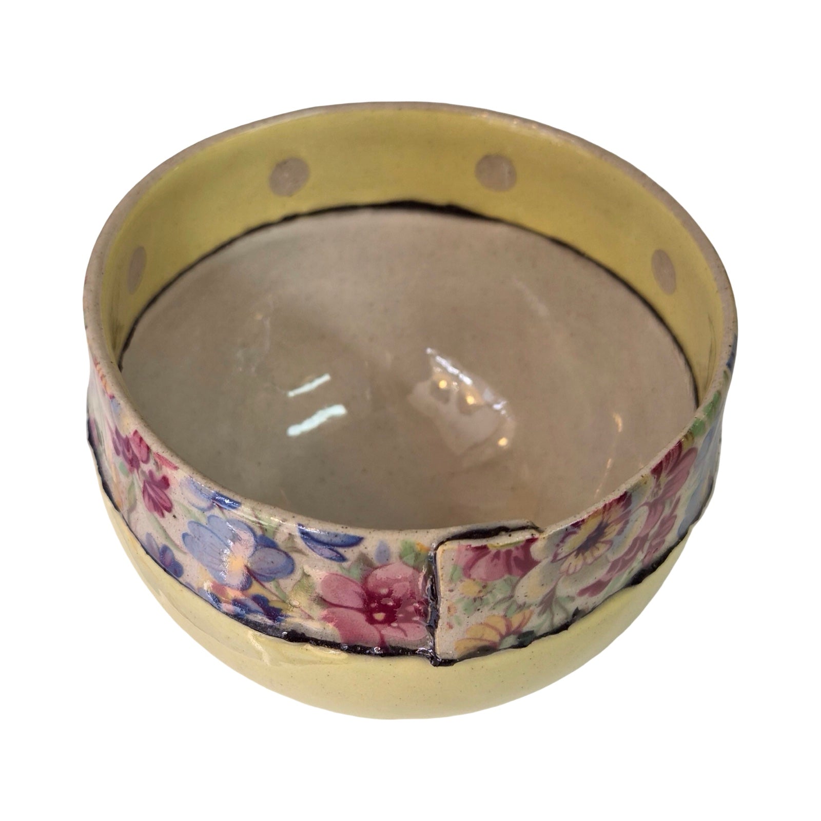 Round ceramic bowl with floral patterned rim on a white background.
