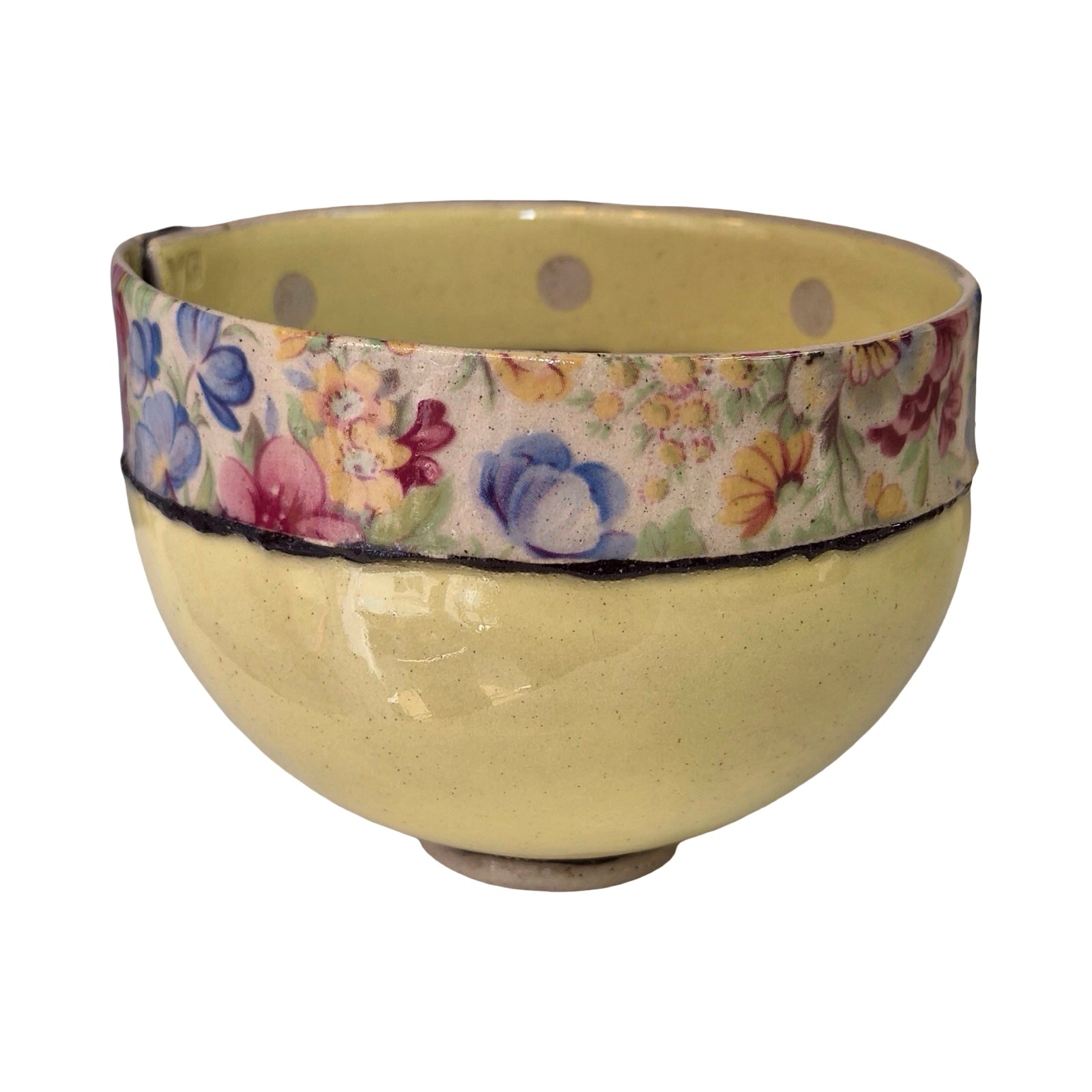Yellow ceramic bowl with floral-patterned band on a white background.
