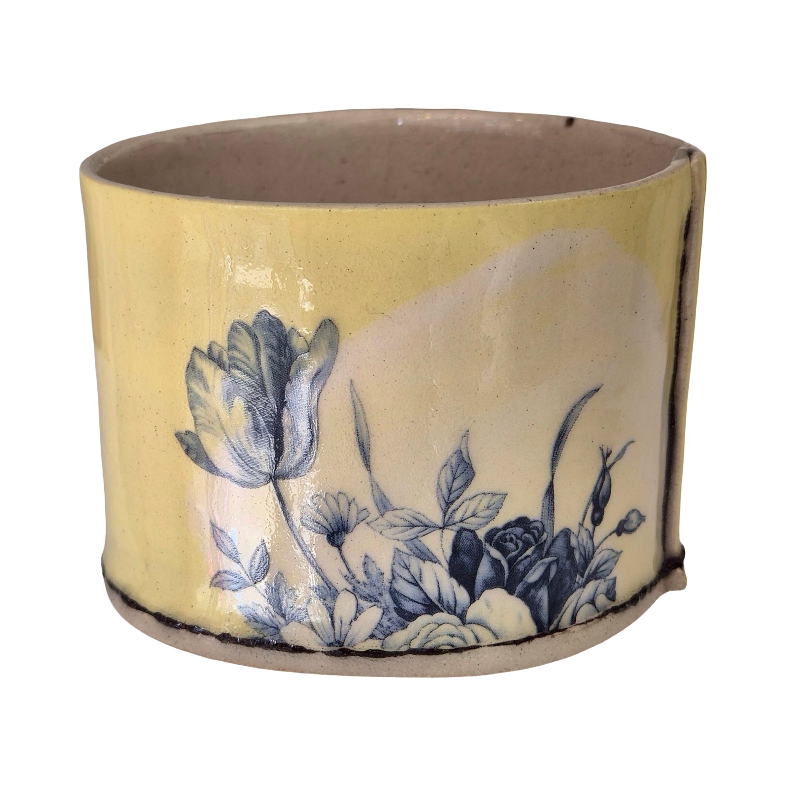 Ceramic planter with blue floral design on a white background.