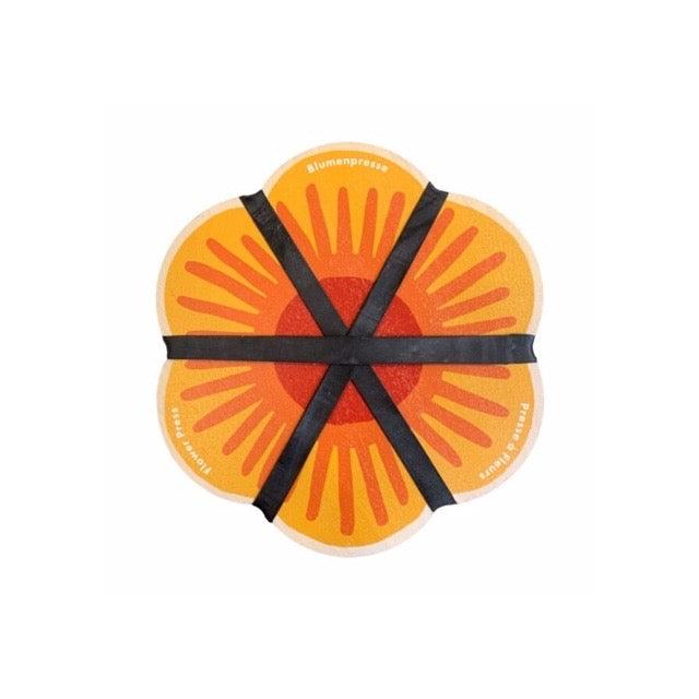 Orange flower-shaped flower press with black ribbons on a white background.
