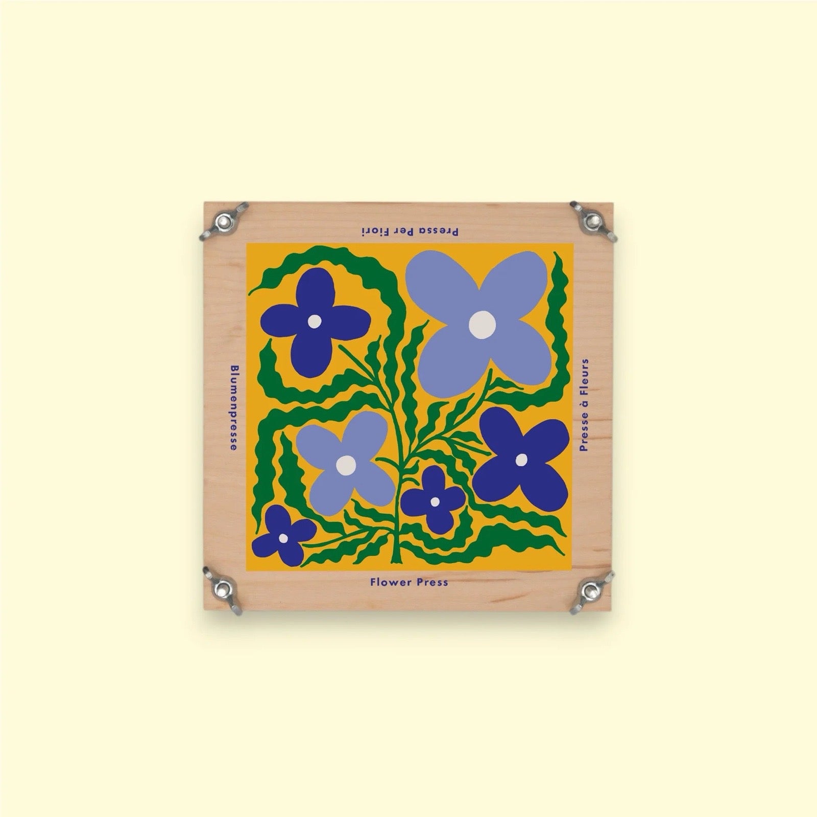 Wooden flower press with blue flowers on a yellow background.