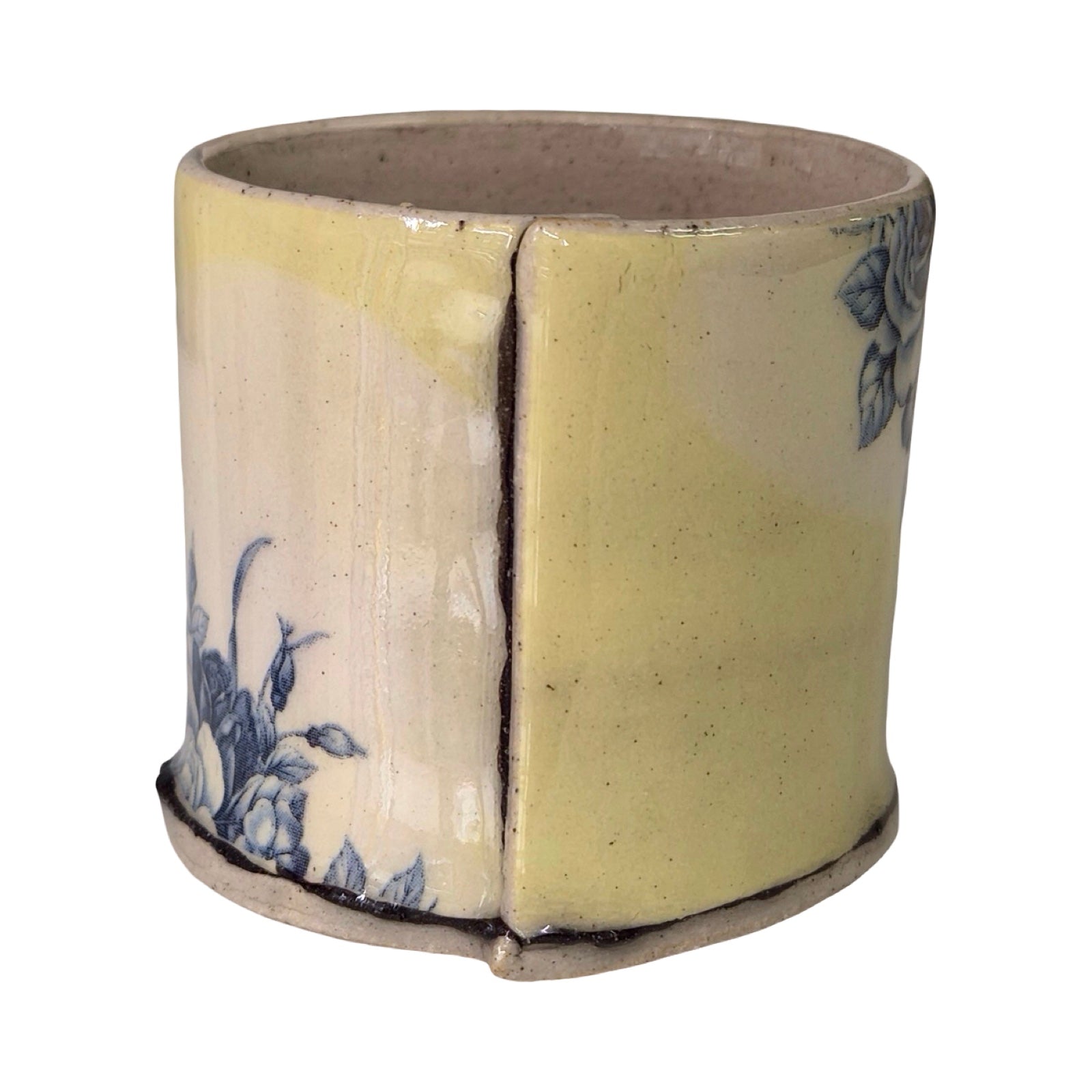 Cylindrical ceramic planter with floral design on a white background.