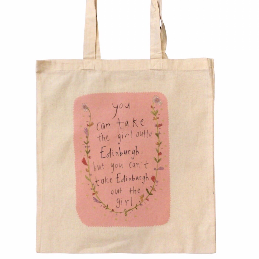 The perfect tote bag for Edinburgh gals everywhere, with the text 'You can take the Girl Outta Edinburgh, but you can't take the Edinburgh out the girl' surrounded by flowers on a pink background.