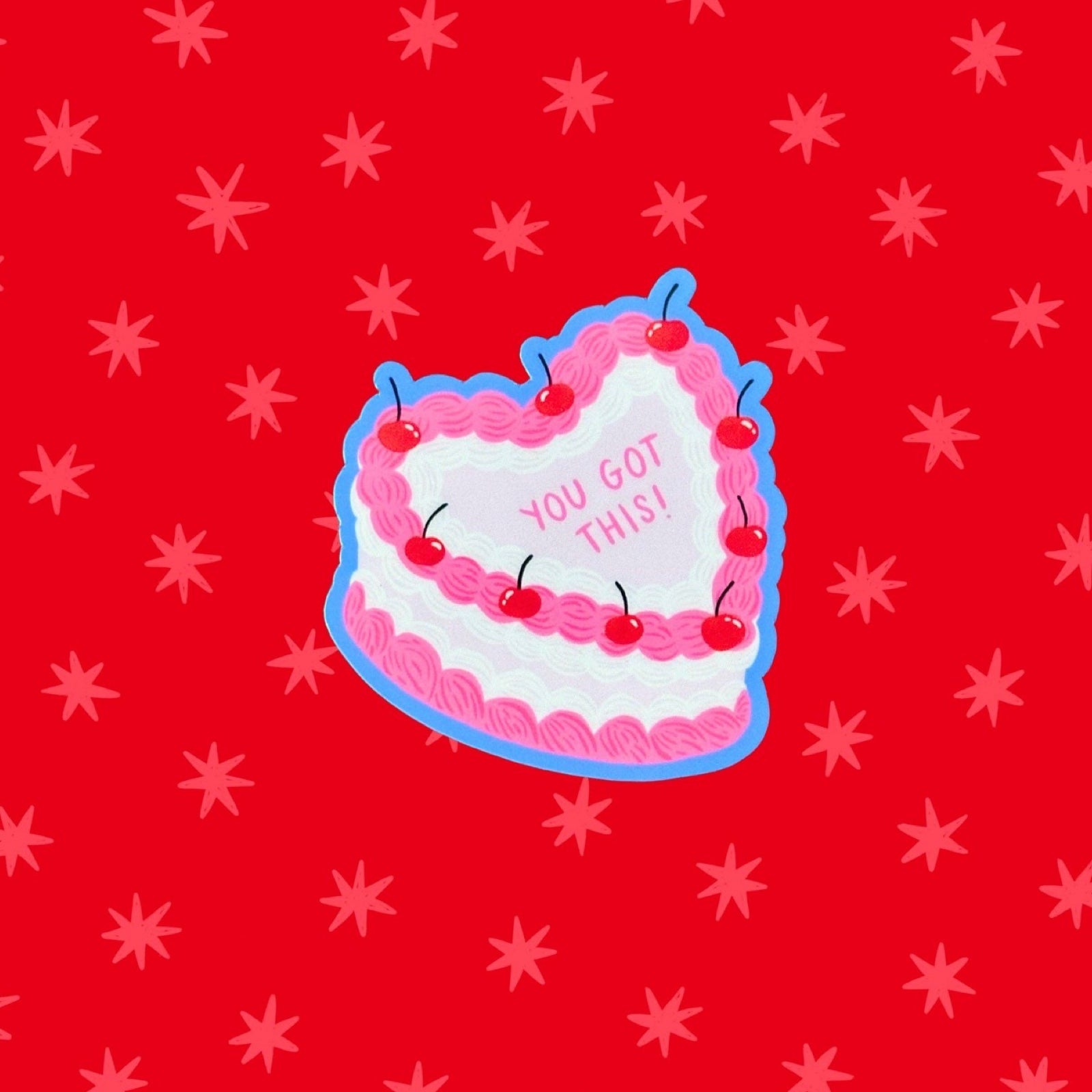 Heart-shaped cake with 'You Got This!' text on a red background with star patterns.