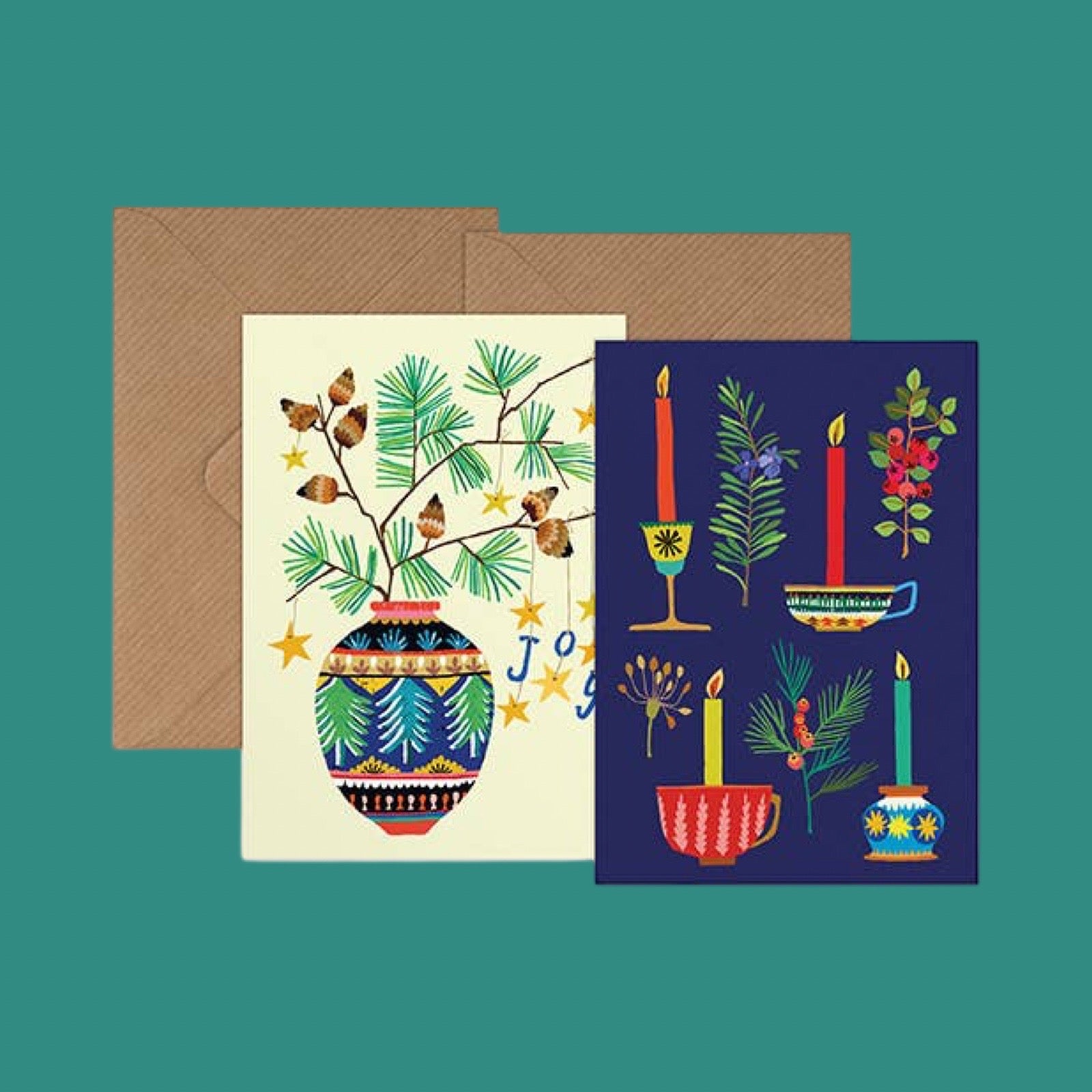 A set of illustrated greeting cards and an envelope on a teal background. The front card is cream with a colorful botanical and decorative design, and the back card is dark navy with matching festive illustrations.